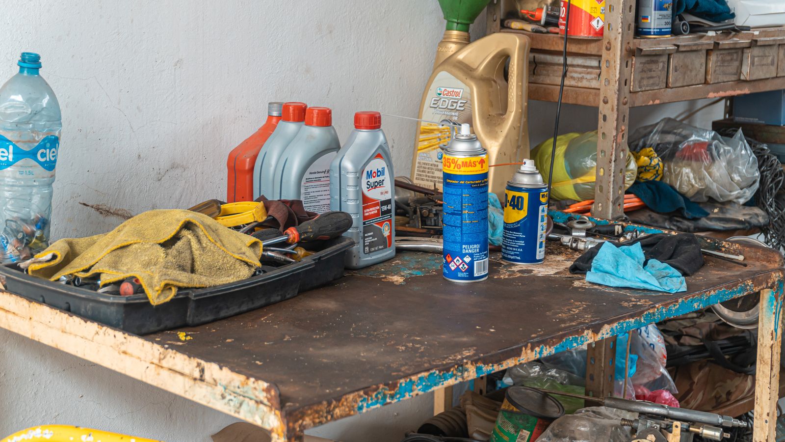 Latas de aceite y herramientas sobre un banco de trabajo desgastado