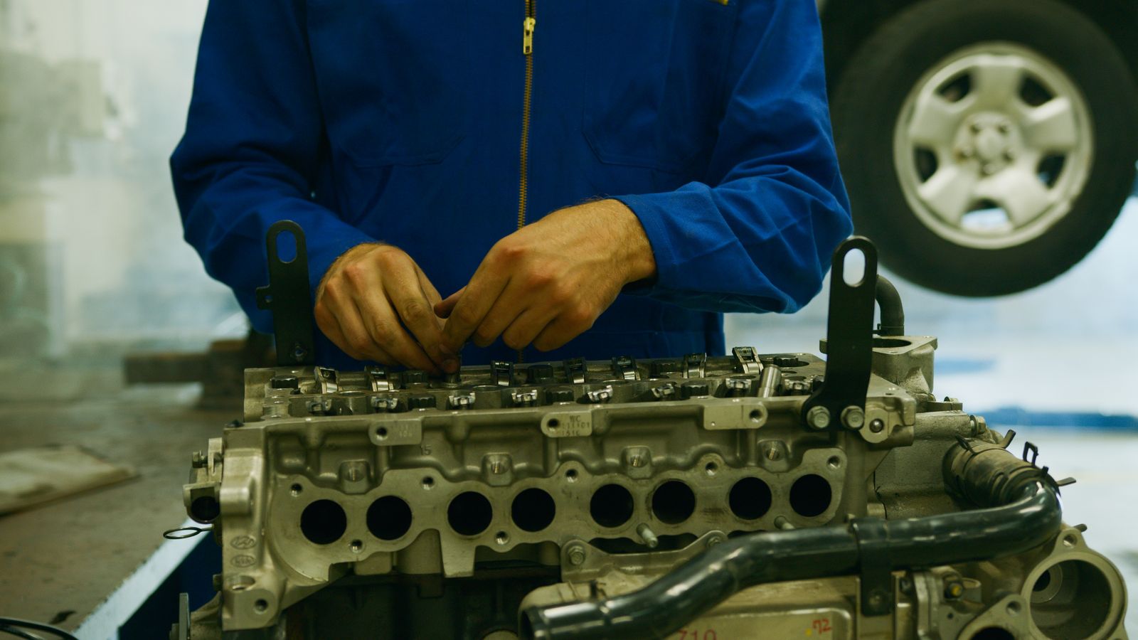 Primer plano de un mecánico reparando una pieza del motor